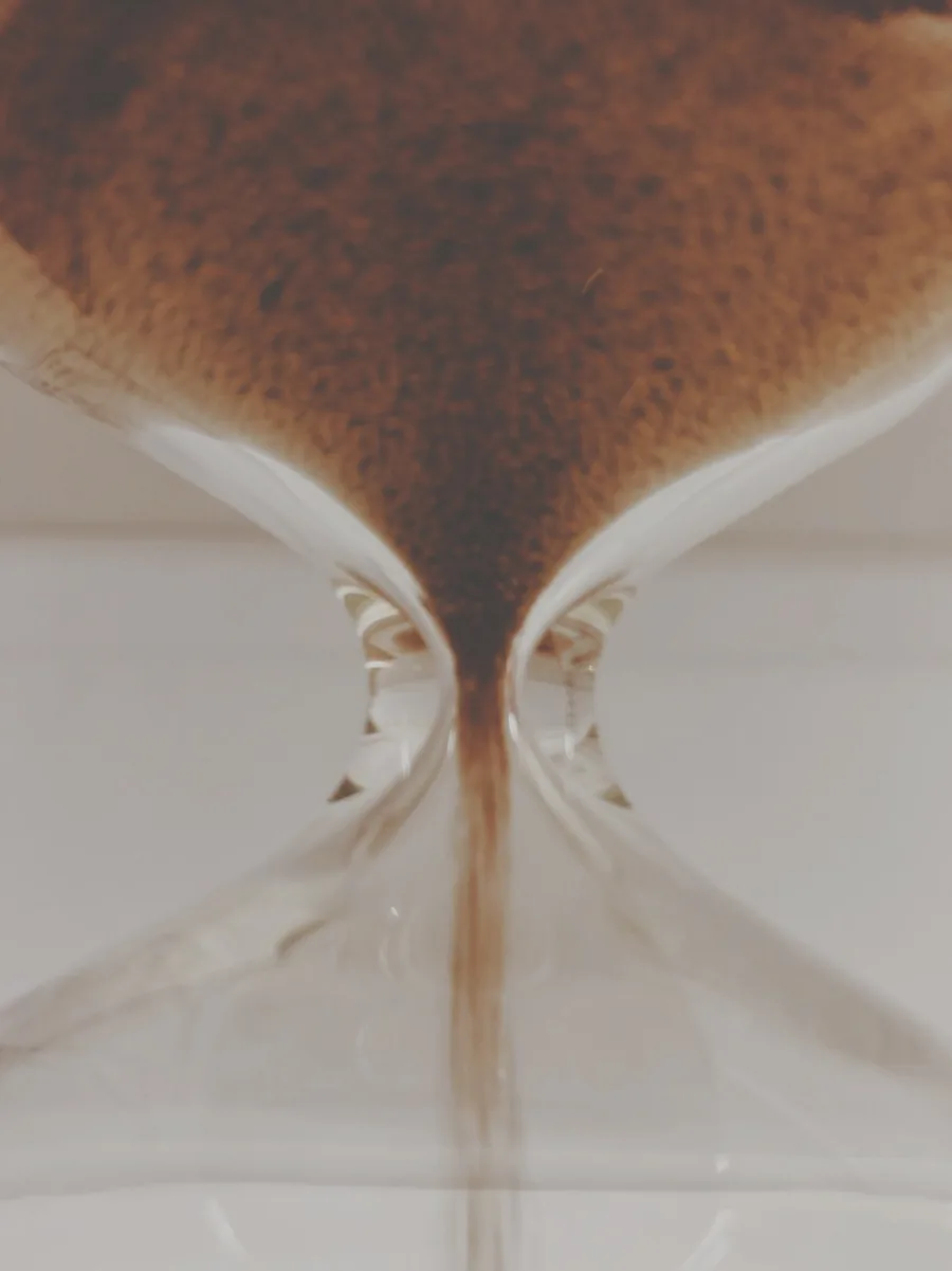 Le sable qui s'écoule dans un sablier, symbole du temps et des cycles